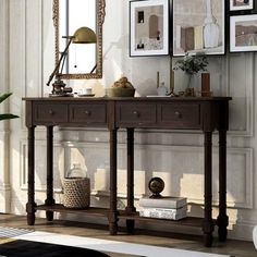 a console table with two drawers and a mirror on top, in front of a white wall