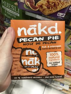 a hand holding up a box of nakd pecan pie