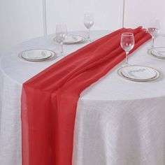 the table is set with wine glasses and place settings for two people to sit at