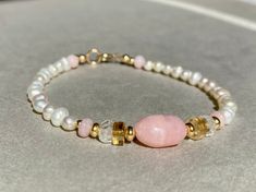 PINK OPAL BRACELET HANDMADE WITH FRESHWATER PEARLS AND GOLD FILLED Freshwater Pearl bracelet with Pink Opal, Aquamarine, Citrine and Gold filled beads. This bracelet comes in a length of 17,5cm.  If you need another length, please let me know when you order. Here you can find all my other bracelets: https://www.etsy.com/de/shop/ilkajewels?ref=seller-platform-mcnav&section_id=24365956 I send all my jewelry pieces nicely packed in a jewelry bag. MATERIAL -freshwater pearl, 4mm -Gold filled beads a Dainty Pearl Bracelet With Natural Stones As Gift, Dainty Pearl Bracelet With Natural Stones, Dainty Natural Stone Pearl Bracelet Gift, Spiritual Pink Jewelry For Birthday, Pink Birthstone Bracelet As Gift, Pink Birthstone Bracelet For Gift, Hand-strung Pearl Bracelet Gift, Gift Pearl Rondelle Bracelet With Gemstone Beads, Rondelle Gemstone Beads Pearl Bracelet As Gift