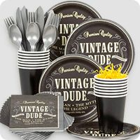 an assortment of black and gold party supplies including plates, cups, napkins and forks