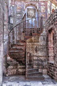 a spiral staircase in an old brick building