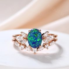 an opal and diamond ring on a white surface