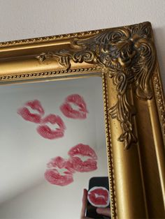 a person is taking a picture of their lipstick prints on the wall in front of a mirror