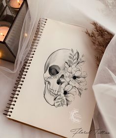 a drawing of a skull with flowers on it's face next to some candles