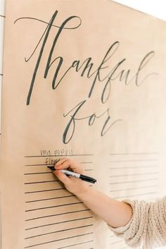 a woman writing on a large piece of paper that says, thank you for me