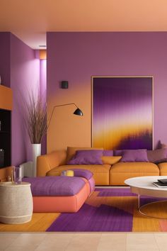 a living room with purple, orange and yellow colors on the walls as well as a white coffee table