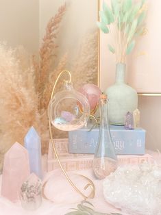 a table topped with vases filled with different types of crystals and plants next to each other