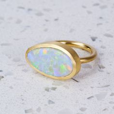 An amazing ring set with a one-off Mackeral Opal from Lightning Ridge, in 18ct Yellow Gold. Weight is 12.8 grams approx. Opal measures 22.6mm x 11.8mm approx. This ring is a size R in 18ct Yellow Gold with a matte finish. For a high-shine finish, please leave a note at checkout. Modern Yellow Gold Oval Opal Ring, Modern Gold Oval Opal Ring, Modern Oval Yellow Gold Opal Ring, Modern 14k Gold Opal Ring With Polished Finish, Modern Opal Ring In 14k Gold With Polished Finish, Modern Oval Opal Ring In Yellow Gold, Modern Gold Opal Rings, Modern Yellow Gold Opal Ring Gift, Modern 14k Gold Opal Gemstone Ring