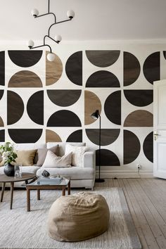 a living room filled with furniture and a large wallpaper pattern on the wall behind it