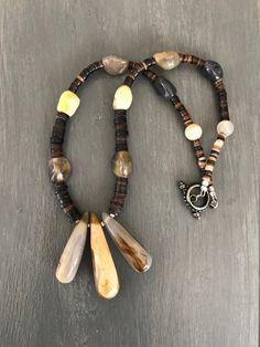 Yellow and Gray Agate Nuggets are interspersed with brown shell heishi beads and lead to a trip of gradated carved agate pendants.  Toggle clasp  Length measured clasp to clasp 19.5"  length two outer pendants 1.5" middle pendant 2"  All materials were reclaimed, repurposed and handmade by me Vintage Clothing & Jewelry with a Southwest Flair Check out my shop for more jewelry and clothing! https://www.etsy.com/shop/sierramadrevintage Carved Agate, Heishi Necklace, Grey Agate, Heishi Beads, Agate Pendant, Toggle Clasp, Necklace Silver, Boho Jewelry, Silver Necklaces