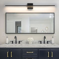 a bathroom with two sinks and a large mirror