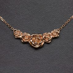 This beautiful and unique botanical necklace features a cluster of blossoming roses intricately rendered in 14k rose gold. Inspired by the boundless and surprising beauty of the natural world, this necklace offers a dreamy air of fairytale romance! The necklace is pictured in solid 14k rose gold and can be made in yellow or white gold as well. The pendant measures 21.6 x 8.8mm. The chain is 18 inches in length.This unique botanical necklace is an Ivy and Rose original design, so you will not fin Pendent Designs, Rose Necklace Gold, Botanical Necklace, Fairytale Romance, Fantasy Things, Rose Blossom, Shiny Rings, Necklace Ideas, Necklace Flower