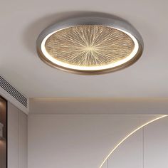 a circular light fixture in the middle of a room with white walls and flooring