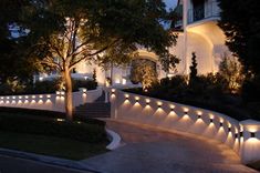 an illuminated walkway leading to a house at night