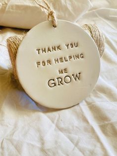 a thank you for helping me grow ornament hanging from twine on a bed