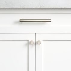 a white cabinet with two handles on it