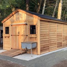 a small wooden shed with a table outside