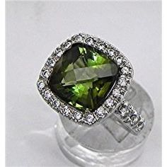 a fancy ring with a green stone surrounded by white diamonds on a clear glass surface