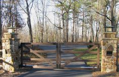 an open gate leading into a wooded area