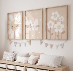 three framed pictures hang on the wall above a wooden bench with pillows and pillow cases