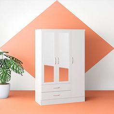 a white cabinet sitting next to a potted plant on top of a pink floor