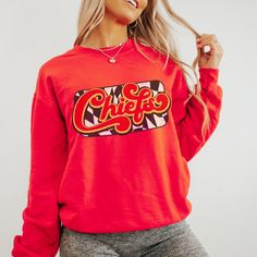 You are going to love this super cute and cozy Kansas City Chiefs Sweatshirt! This is a unisex fit sweatshirt, made with direct to film transfer, no vinyl or sublimation is used.  In order to provide the most color choices, sweatshirts in Pepper, Grey, and Ivory are made using Comfort Colors 100% soft ring-spun cotton, while sweatshirts in white, black, red, and sand are made using Gildan Cozy Feel, 50% cotton 50% poly blend. Both have a ribbed collar and relaxed fit and will make a great addition to your game day wardrobe.  T-shirts are comfort colors soft washed garment-dyed tees, renowned for their softness, comfort, and durability. Made with 100% ring-spun cotton, and sure to make an excellent choice for comfortable daily wear. T-shirts have double needle stitching throughout, sewn in Cotton Sweatshirt With Graphic Print For Game Day, Cotton Graphic Print Sweatshirt For Game Day, Retro Long Sleeve Pre-shrunk Sweatshirt, Retro Graphic Print Sweatshirt For Game Day, Pop Culture Graphic Print Sweatshirt For Fall, Fun Cotton Sweatshirt With Graphic Print, Red Cotton Band Merch Sweatshirt, Red Graphic Print Sweatshirt For Game Day, Fun Long Sleeve Sweatshirt With Screen Print