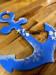 a wooden table with a blue painted anchor and starfish decoration on it's side