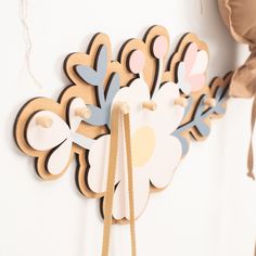 a wooden clock hanging from the side of a wall next to a flower shaped decoration