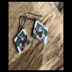 Handwoven Miyuki delica seed bead earrings in an original design created to celebrate the Iris! This piece is brick stitched with eggplant purple, black, yellow, iridescent lavender, luster light pink, and grass green beads. Measures around 1.5 inches in drop length and 1 inch wide and has hypoallergenic (nickel and lead free) brass hammered ear hooks in dark antique silver. For best care, store earrings flat when not wearing to retain shape of beadwork. Each earring is designed and handmade with love. Purple Handwoven Earrings As A Gift, Store Earrings, Pumpkin Earrings, Jasper Earrings, Purple Iris, Eggplant Purple, Green Beads, Grass Green, Original Jewelry