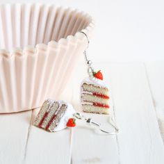 a piece of cake is sitting next to a cupcake tin with a strawberry on it