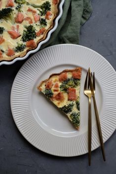 a slice of quiche with ham and broccoli on a plate next to a fork