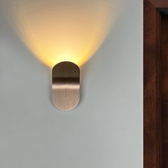 a light that is on the side of a wall next to a door with a handle