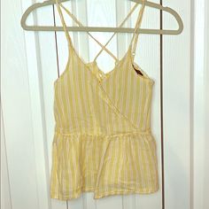 Nwot American Eagle Striped Peplum Tank Top With Front Hook To Hold It In Place Back Has Cross Cross Detailing Size Xs Staple Piece For Transitioning Into The Spring Season And Would Look Great Paired With Some White Jeans For Easter Or Any Spring Occasion Cute Yellow Sleeveless Top, Cute Yellow Summer Tops, Mustard Sleeveless Top For The Beach, Casual Mustard Tops For Vacation, Mustard V-neck Top For Beach, Yellow Cotton Beach Top, Peplum Tank Top, Spring Season, Staple Pieces