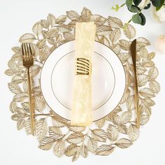 a white plate topped with a golden fork and knife next to a gold napkin on top of it