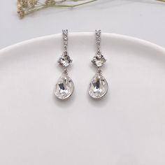 Introducing our stunning Swarovski Pear Crystal Dangle Earrings, featuring clear Swarovski crystals in a timeless teardrop design. These clear white teardrop earrings are perfect for adding elegance to any outfit. Whether you're looking for classic bridal earrings, chic bridesmaid earrings, or formal earrings for a special event, these Swarovski minimalist earrings are the ideal choice. With their crystal hanging style, they catch the light beautifully, making them a must-have wedding earring. E Diamond White Teardrop Crystal Bridal Earrings, Classic White Crystal Earrings, White Sparkling Drop Bridal Earrings, Silver Crystal Long Drop Teardrop Earrings, Sparkling White Drop Bridal Earrings, Sparkling Pear-shaped Crystal Bridal Earrings, Silver Crystal Drop Bridal Earrings, Silver Crystal Pear-shaped Chandelier Earrings, Long Drop Silver Crystal Earrings For Weddings