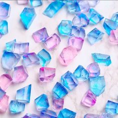 blue and pink crystals are scattered on a marble surface