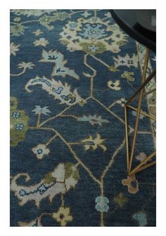 a blue rug with an ornate design on the bottom, and a black table in front