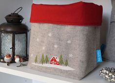 a small storage bag with a house on it and two birds sitting next to it