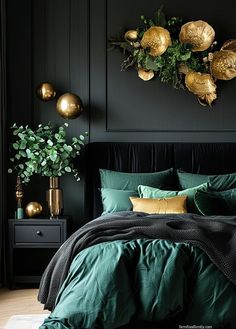 a bedroom with black walls, green bedding and gold decorations on the headboard