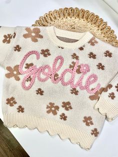 Our custom hand embroidered name sweaters are sure to look adorable on the sweet little one in your life!  Give them as gifts for baby showers, name announcements, first birthday's, Xmas gifts, and more!  Sweaters are a chunky knit and an oversized fit to wear as your baby grows.  These are perfect to wear in the fall, winter, or spring. Choose how many letters are in the name you want embroidered.  Fill in the personalization box with the name and thread color of your liking. Care Instructions Cute Cream Crew Neck Sweater, Cute Cotton Sweater With Embroidered Logo, Cute Crew Neck Sweater With Embroidered Logo, Cute Crew Neck Sweater With Custom Embroidery, Cute White Embroidered Sweater, Cream Long Sleeve Sweater With Letter Embroidery, Cute White Sweater With Embroidered Text, White Cute Sweater With Embroidered Text, Pink Winter Sweater With Embroidered Logo