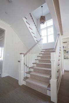 there is a staircase leading up to the second floor in this house with white walls and wood floors