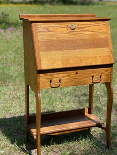 an old wooden desk sitting in the grass