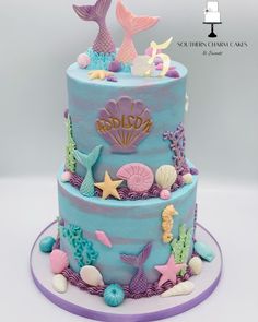 a three tiered cake decorated with sea animals and seashells