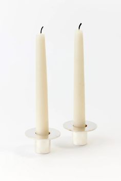 two white candles sitting on top of each other