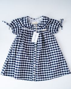 Our gorgeous new Carrie dress is fully lined and 100% cotton. It is available in Blue and White French Floral, Blue and White Gingham and Blue and White Ticking Stripe. The very cute puff sleeve is finished off with a lovely bow and the collar is beautifully edged with a small frill. This is such a versatile little dress to take on holiday, it can so easily be dressed up or down and is perfect for tea parties, going out to lunch or dinner or just playing in the countryside or seaside. And just throw on a cardigan for those cooler days, infact this little dress could carry through to the winter months if you add stockings, wellies and a winter coat. Limited stock in each size and colourway so be sure you don't miss out. Spring Blue Plaid Cotton Dress, Cotton Gingham Plaid Dress With Ruffles, Gingham Plaid Cotton Dress With Ruffles, Classic Short Sleeve Gingham Dress, Classic Gingham Short Sleeve Dress, Classic Gingham Dress With Short Sleeves, Short Sleeve Cotton Plaid Dress For Spring, Short Sleeve Cotton Plaid Spring Dress, Fitted Blue Plaid Cotton Dress