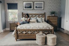 a woman sitting on top of a bed in a bedroom