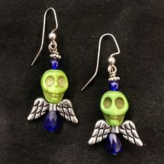 "This is a unique set of silver metal ear wire earrings featuring green howlite stone skulls with faceted blue glass beads and silver wings. Each earring is just under 2\" long and 3/4\" wide. Each skull is 1/2\" by just under 1/2\". Make sure to check out my shop for all sorts of hair accessories, jewelry, magnets, trinket boxes, coasters, and more! Green Skull Earrings, Green Skulls, Skull Earrings, Skulls Wings, Green Skeleton, Angel Wings, Green Blue, Angel Skull, Silver Wings" Skeleton Angel Wings, Skull Bead Jewelry, Skeleton Angel, Green Skeleton, Angel Skull, Rockabilly Earrings, Green Skull, Diy Earrings Easy, Silver Hair Comb