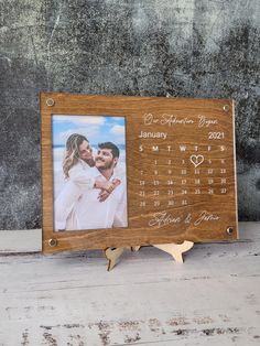 a wooden calendar frame with a couple holding each other