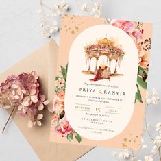 an image of wedding card with flowers on the table next to it's envelope